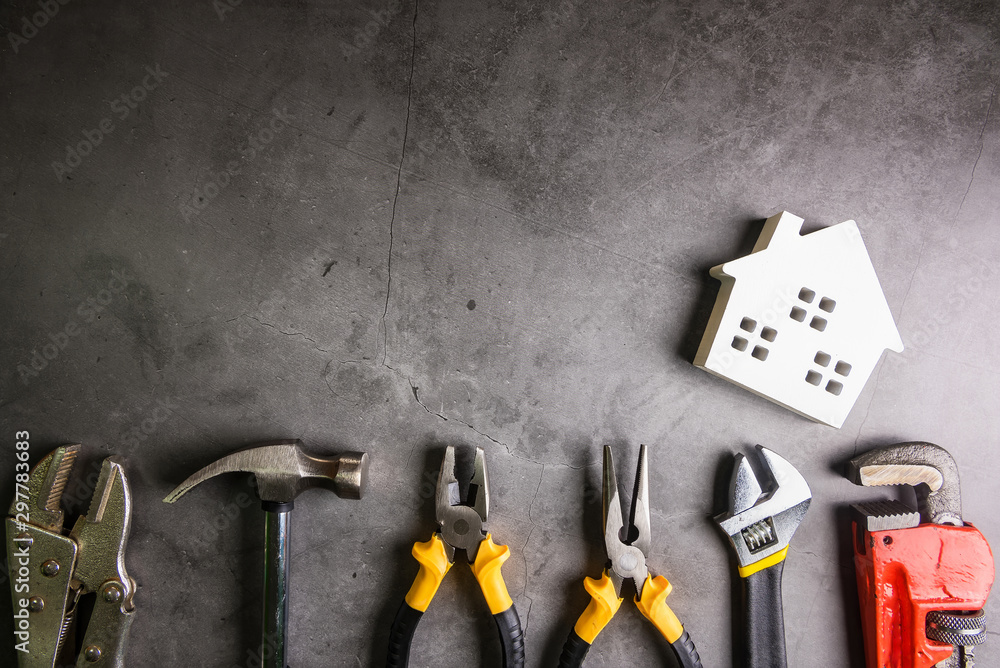 Wooden house and construction tools on stone pattern background with copy space.Home Repair concept, Repair maintenance concept, Renovation concept.